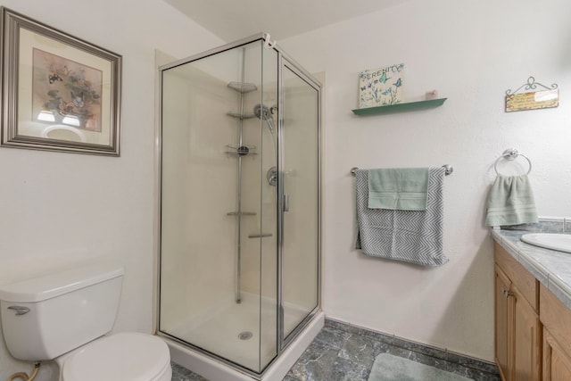bathroom featuring a stall shower, toilet, and vanity