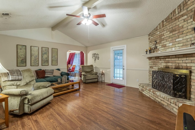 living area featuring a textured ceiling, wood finished floors, ceiling fan, and a fireplace