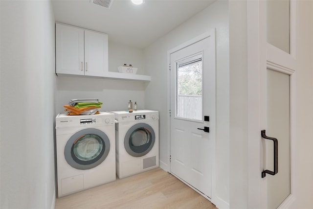 7319 Rutgers Dr, Dallas, TX 75214 - laundry area featuring washing machine and dryer, cabinet space, and light wood-style floors