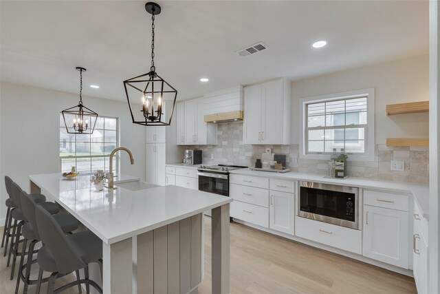 7319 Rutgers Dr, Dallas, TX 75214 - kitchen with built in microwave, a sink, stainless steel electric range oven, a chandelier, and backsplash