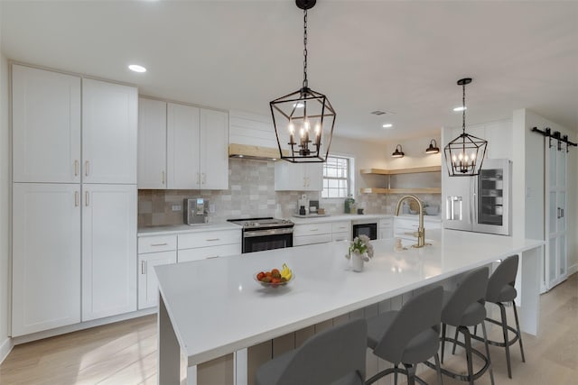 7319 Rutgers Dr, Dallas, TX 75214 - kitchen with electric range, a chandelier, light wood-style flooring, backsplash, and recessed lighting