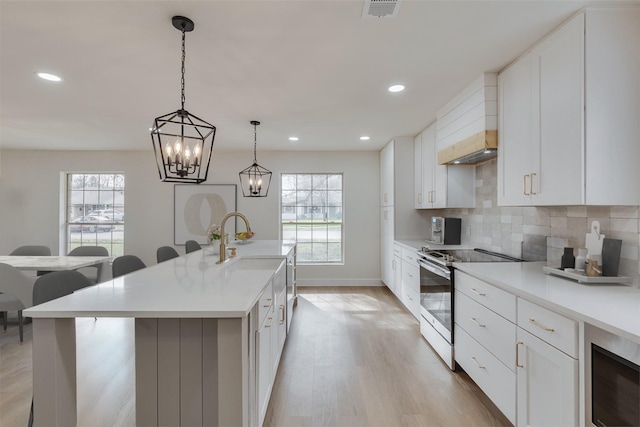 7319 Rutgers Dr, Dallas, TX 75214 - kitchen with electric range oven, plenty of natural light, light wood-style flooring, backsplash, and recessed lighting