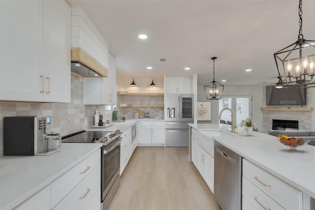 7319 Rutgers Dr, Dallas, TX 75214 - kitchen with appliances with stainless steel finishes, a sink, a chandelier, tasteful backsplash, and light countertops
