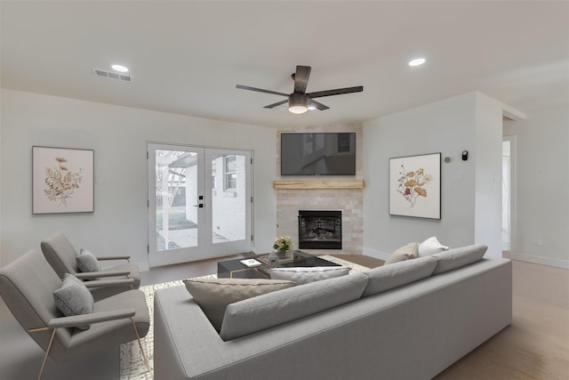 7319 Rutgers Dr, Dallas, TX 75214 - living area with a ceiling fan, a tile fireplace, french doors, baseboards, and wood finished floors