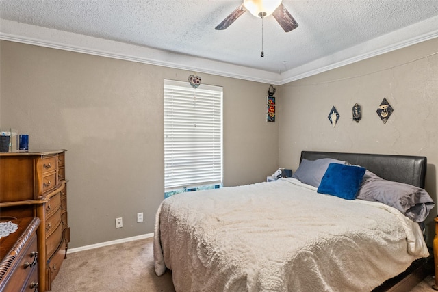 carpeted bedroom featuring a textured ceiling, crown molding, a ceiling fan, and baseboards
