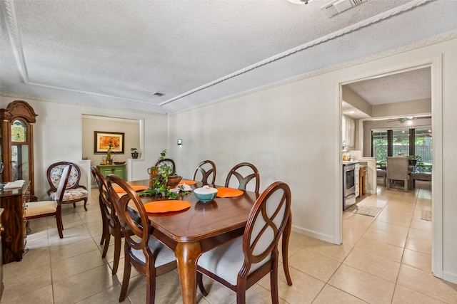 dining space with a textured ceiling and light tile patterned flooring
