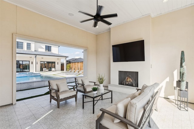 living area featuring ornamental molding, a fireplace with raised hearth, a ceiling fan, and tile patterned floors