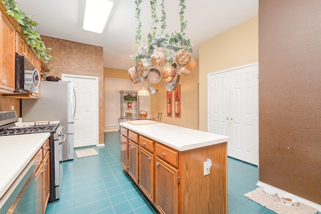5509 Allen Ln, Rowlett, TX 75088 - kitchen with appliances with stainless steel finishes, dark tile patterned flooring, light countertops, and brown cabinets