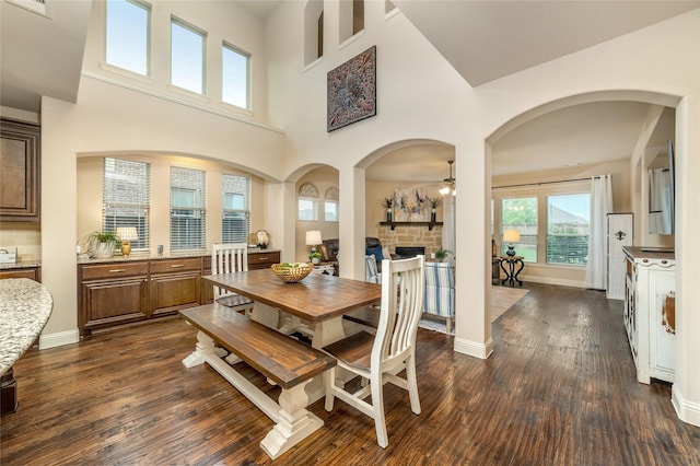 1519 Eminence Ln, Saint Paul, TX 75098 - dining room with ceiling fan, dark wood finished floors, a fireplace, a high ceiling, and baseboards