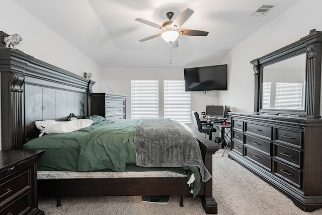bedroom featuring light colored carpet, multiple windows, an office area, and a ceiling fan