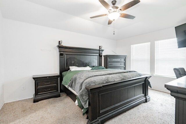 bedroom featuring light colored carpet, baseboards, and ceiling fan