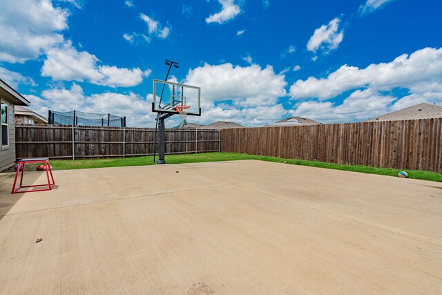 view of sport court with a fenced backyard and basketball court