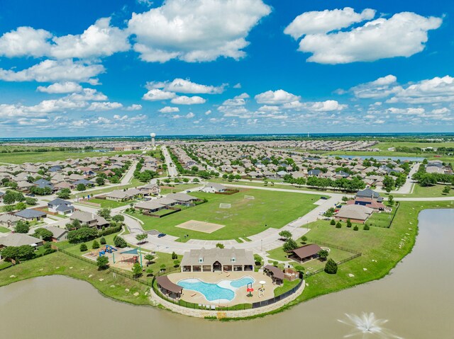 aerial view of residential area with a nearby body of water and a pool area