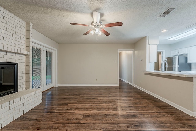 1600 Lagoona Ln, Edgecliff Village, TX 76134 - unfurnished living room featuring dark wood-style floors, a ceiling fan, a textured ceiling, baseboards, and a fireplace