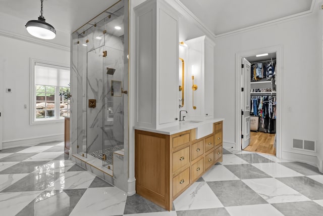bathroom featuring crown molding, a marble finish shower, vanity, a walk in closet, and marble finish flooring