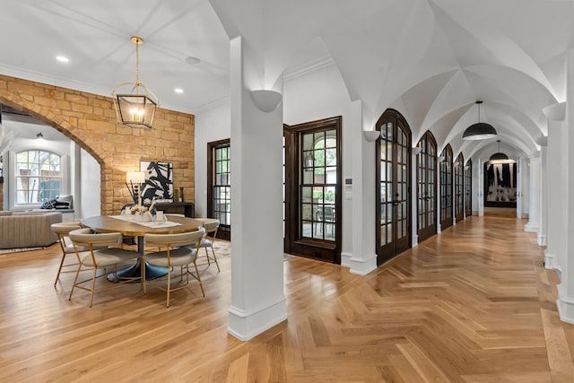 dining space featuring arched walkways, healthy amount of natural light, recessed lighting, baseboards, and crown molding