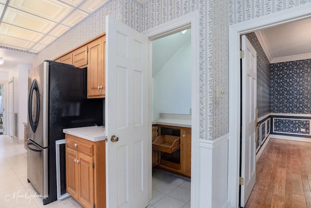 8705 W Wilderness Way, Shreveport, LA 71106 - kitchen with wallpapered walls, freestanding refrigerator, light countertops, ornamental molding, and a wainscoted wall