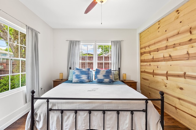 5533 Bonita Ave, Dallas, TX 75206 - bedroom featuring dark wood-style floors, multiple windows, ceiling fan, and wood walls