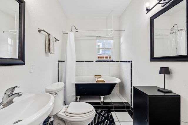 5533 Bonita Ave, Dallas, TX 75206 - full bath featuring a sink, tile patterned floors, a soaking tub, tile walls, and toilet