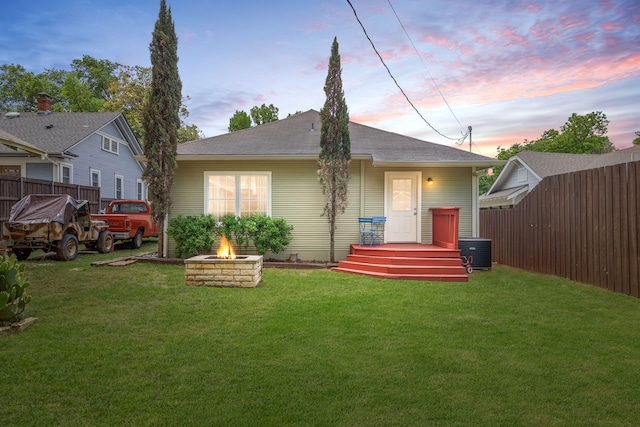 5533 Bonita Ave, Dallas, TX 75206 - back of house at dusk with a fire pit, central AC unit, and a shingled roof