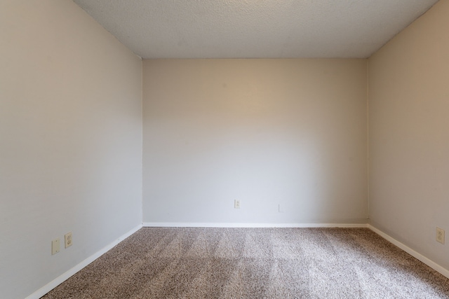 carpeted empty room with baseboards and a textured ceiling