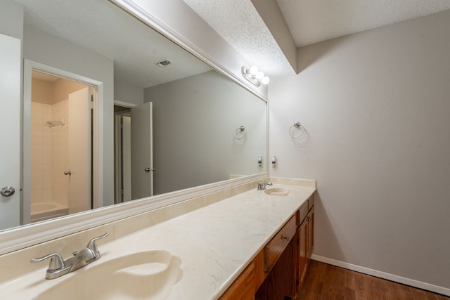 full bathroom with wood finished floors, double vanity, baseboards, and tub / shower combination