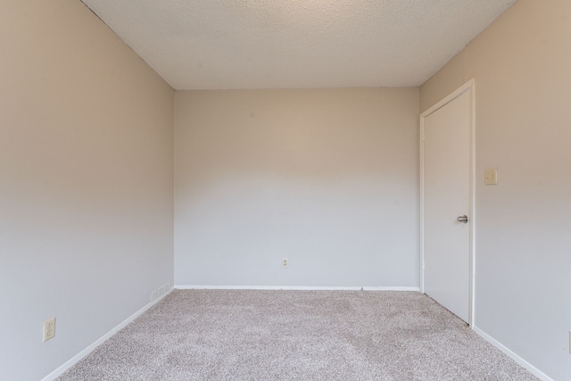 carpeted empty room featuring baseboards
