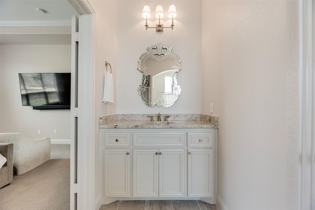 bathroom with vanity, ornamental molding, and baseboards