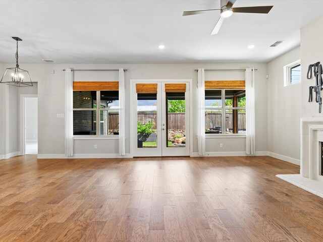 323 Green Meadow Dr, Little Elm, TX 75068 - unfurnished living room with ceiling fan, a chandelier, wood finished floors, baseboards, and recessed lighting