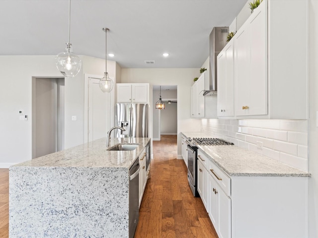 323 Green Meadow Dr, Little Elm, TX 75068 - kitchen featuring appliances with stainless steel finishes, a sink, wall chimney exhaust hood, wood finished floors, and recessed lighting