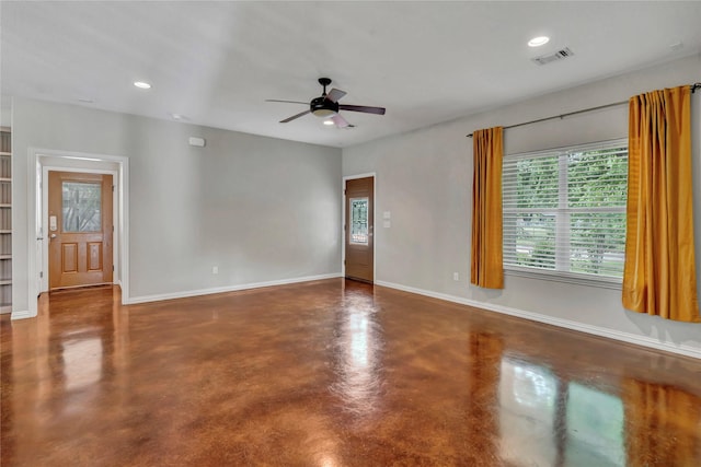 unfurnished room with finished concrete floors, a ceiling fan, healthy amount of natural light, baseboards, and recessed lighting
