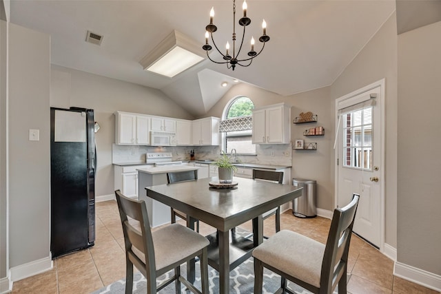 dining room featuring plenty of natural light, a chandelier, lofted ceiling, and light tile patterned floors