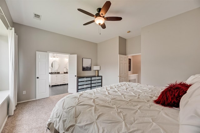 carpeted bedroom featuring lofted ceiling, connected bathroom, baseboards, and a ceiling fan