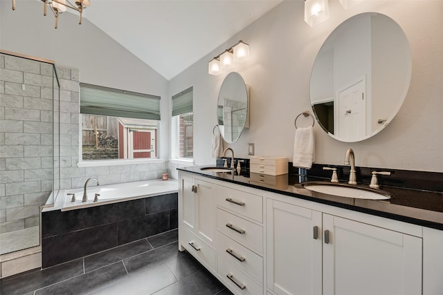 bathroom featuring lofted ceiling, tile patterned flooring, double vanity, a garden tub, and a walk in shower