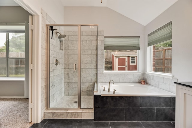 bathroom featuring a stall shower, a garden tub, vaulted ceiling, and tile patterned floors