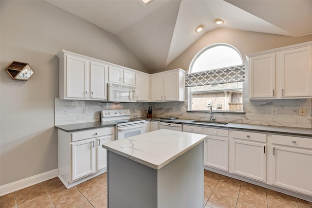 kitchen featuring white appliances, a sink, vaulted ceiling, a kitchen island, and white cabinetry