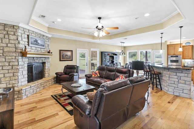3568 Green Meadows Dr, Glen Rose, TX 76043 - living area featuring crown molding, a raised ceiling, light wood-style flooring, a ceiling fan, and a fireplace