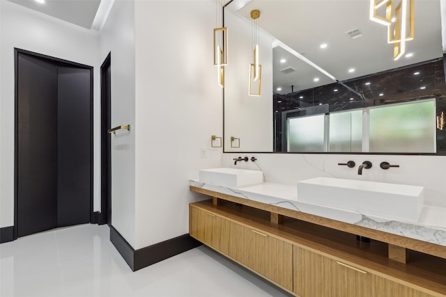 bathroom featuring double vanity, an enclosed shower, baseboards, and tile patterned flooring