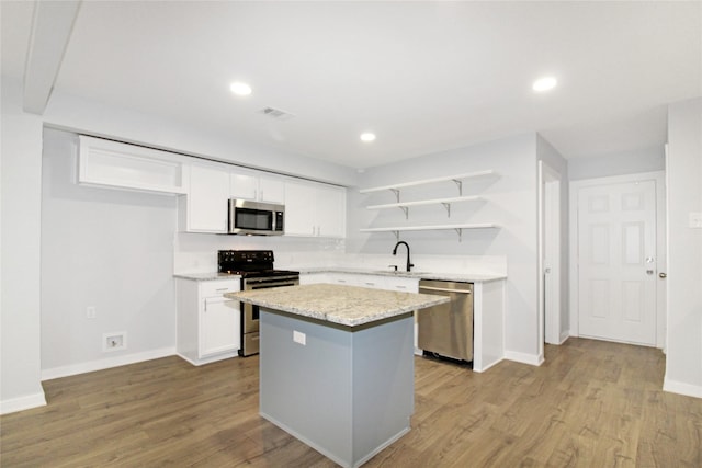 14590 Coffee Ln, Scurry, TX 75158 - kitchen with stainless steel appliances, open shelves, a kitchen island, white cabinetry, and wood finished floors