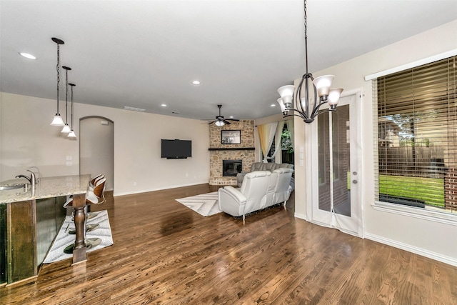 5112 Fringetree Dr, Mckinney, TX 75071 - living area with a fireplace, a ceiling fan, dark wood-style floors, recessed lighting, and arched walkways