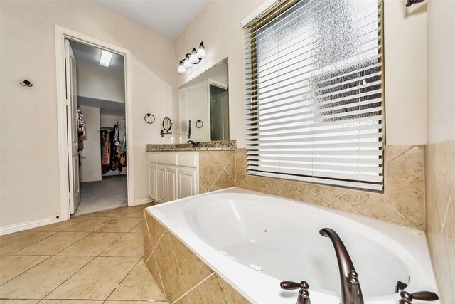 5112 Fringetree Dr, Mckinney, TX 75071 - bathroom featuring a walk in closet, vanity, a bath, tile patterned floors, and baseboards