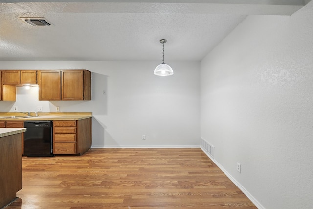 6708 S Creek Dr, Fort Worth, TX 76133 - kitchen with dishwasher, light wood-type flooring, a textured ceiling, light countertops, and brown cabinetry