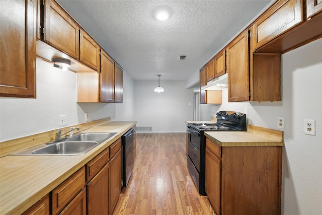 6708 S Creek Dr, Fort Worth, TX 76133 - kitchen with black appliances, under cabinet range hood, a sink, light countertops, and light wood-style floors