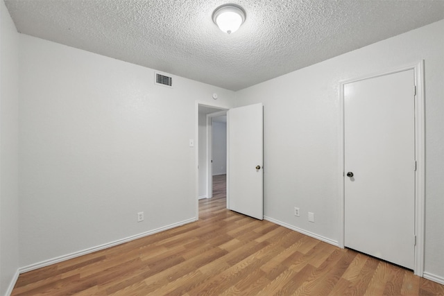 6708 S Creek Dr, Fort Worth, TX 76133 - unfurnished bedroom with wood finished floors, a textured ceiling, and baseboards
