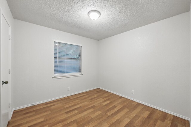 6708 S Creek Dr, Fort Worth, TX 76133 - unfurnished room with wood finished floors, a textured ceiling, and baseboards
