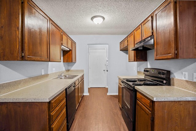 6708 S Creek Dr, Fort Worth, TX 76133 - kitchen featuring under cabinet range hood, black appliances, dark wood-type flooring, a textured ceiling, and light countertops