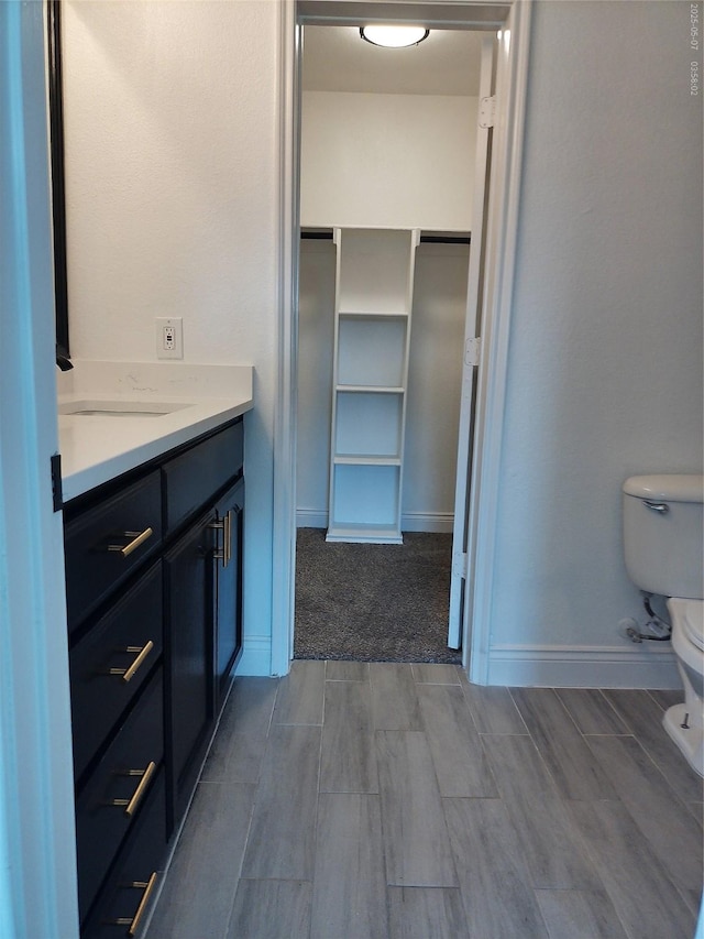 6025 Melanie Dr, Fort Worth, TX 76131 - bathroom featuring toilet, wood tiled floors, vanity, and a spacious closet