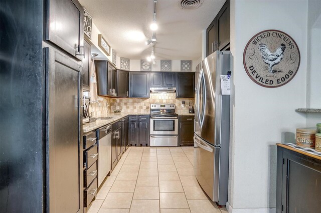 3554 Cromart Ct N, Fort Worth, TX 76133 - kitchen featuring stainless steel appliances, tasteful backsplash, light tile patterned flooring, under cabinet range hood, and light stone counters