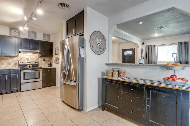 3554 Cromart Ct N, Fort Worth, TX 76133 - kitchen with appliances with stainless steel finishes, under cabinet range hood, light tile patterned floors, tasteful backsplash, and crown molding