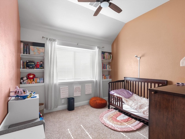 bedroom with lofted ceiling, a crib, carpet, and ceiling fan